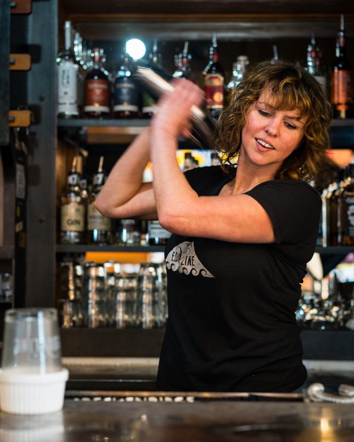Bartender shaking a cocktail behind the Eddyline bar