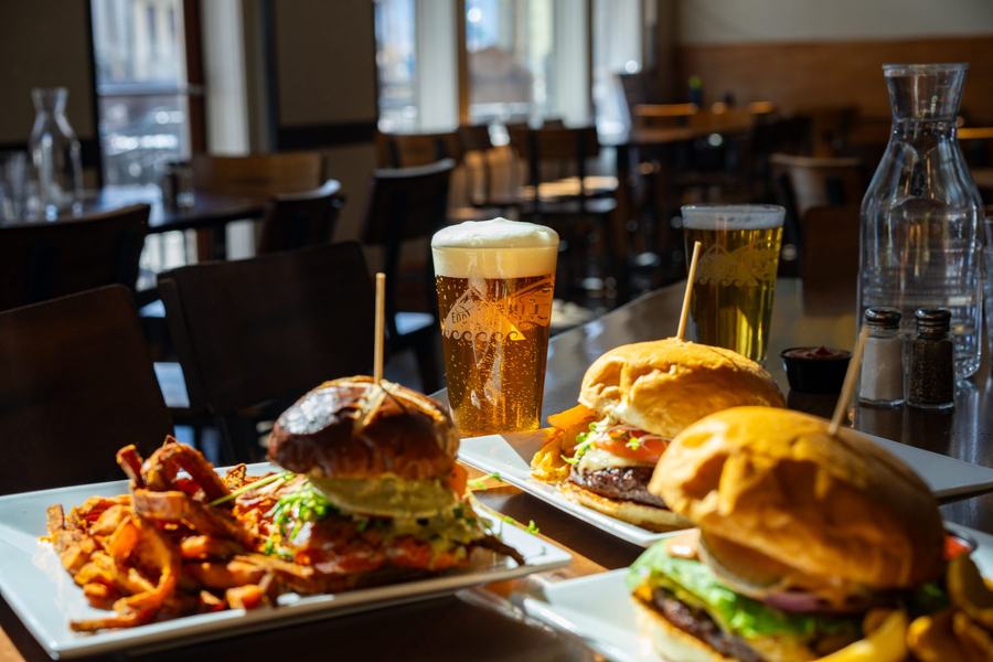 Two burgers with sweet potato fries and pints of Eddyline beer